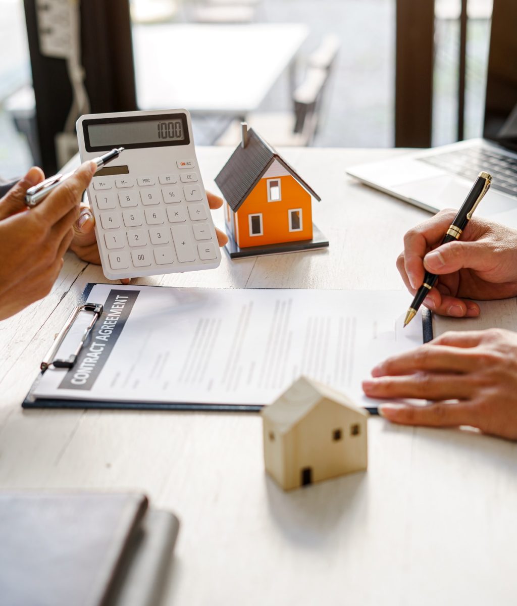 Real-estate agent sign for home contract property for sale in the office with buyer. Real-estate agent sign for home contract property for sale in the office with buyer.